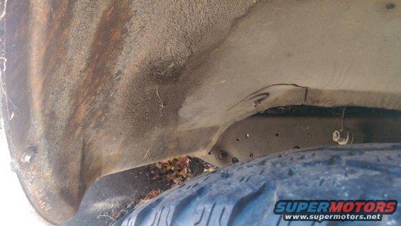 Truck wheel well with rust and a tire visible. A Supermotors logo is in the corner