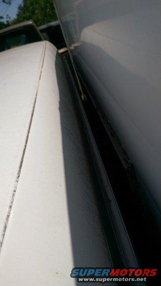 White pickup truck bed rail and open door gap