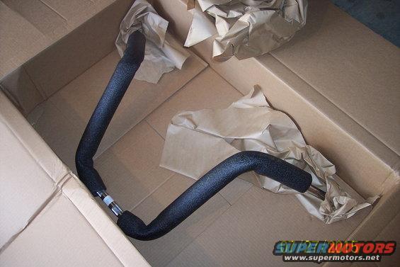 Black motorcycle handlebars in a cardboard box