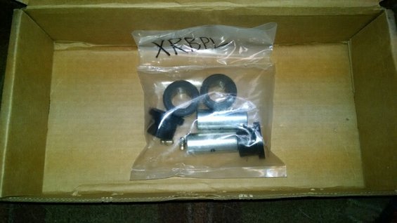 Bag of suspension parts with 'XRPBL' written on it, inside a cardboard box