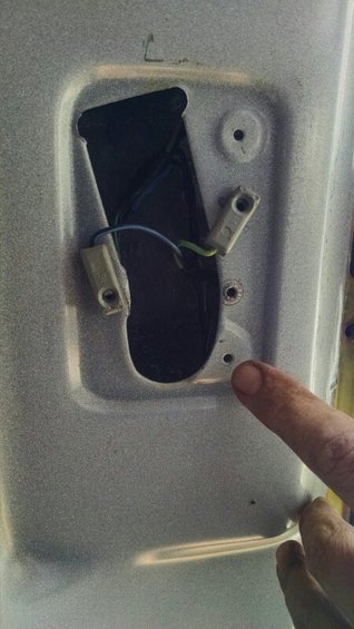Silver interior door panel with exposed wiring and mounting points for a light fixture