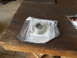 1992 Ford Bronco - A metal part, possibly a bearing race, is shown in its packaging on a wooden surface.