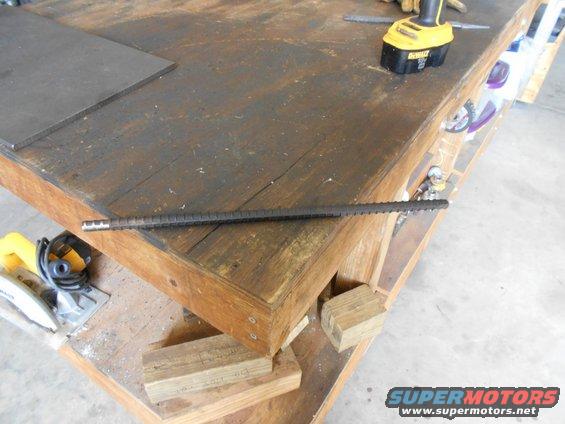 Rebar lying on a wooden workbench with tools nearby