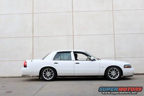 White 2000 Mercury Grand Marquis sedan, side view, parked against a tiled wall