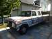 1970 Ford F-250 - This weathered 1970 Ford F-250 crew cab pickup truck sits in a driveway, showing signs of age and disrepair.