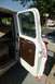 1970 Ford F-250 - The driver's side door of an old pickup truck is open, revealing the interior door panel and a glimpse of the cab.