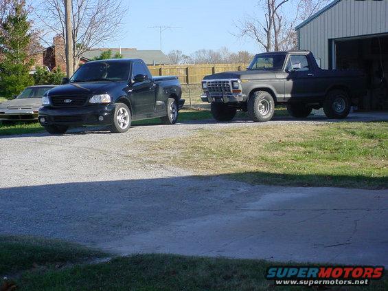 Black 2001 Ford F-150 Lightning parked next to a dark gray 1978 Ford Bronco