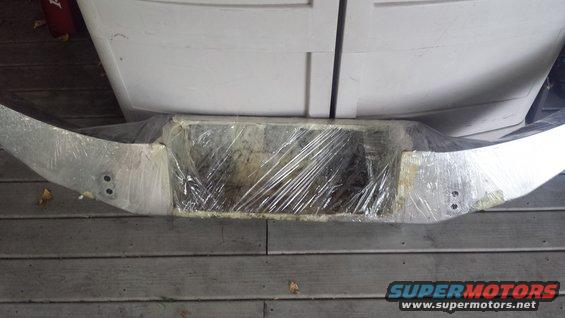 I used a combo of wire wheels and Evapo-rust on the bumper to clean up the back side.  Here is is all wrapped up and soaking.