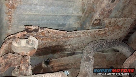 The heat shield above the muffler was only hanging on by the rust.  I barely pulled on it and it broke loose.  In this pic, I had pushed it back up.