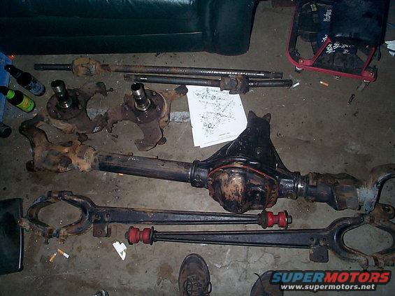 Dana 44 axle assembly with differential housing, knuckles, and drive shafts on concrete floor