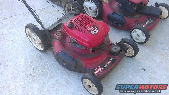 Red Toro Recycler lawn mower with 6.5 HP engine, side view. Another mower behind