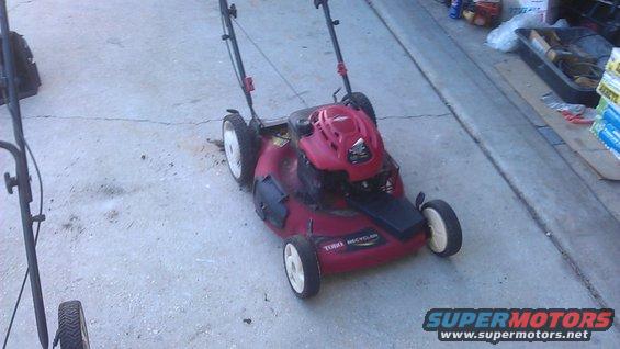 Red Toro Recycler lawn mower with white wheels on concrete