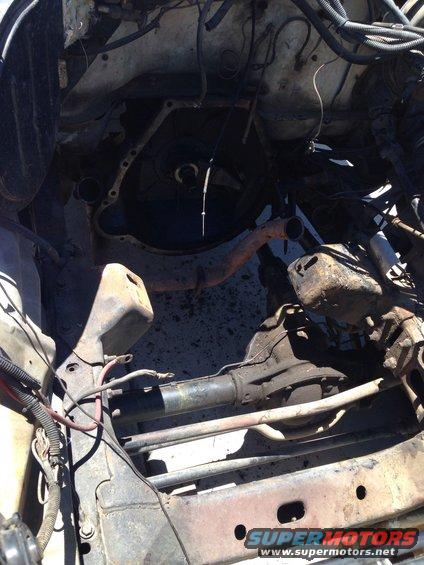 Underside view of a vehicle's engine bay with transmission and exhaust components visible. Some wiring is present