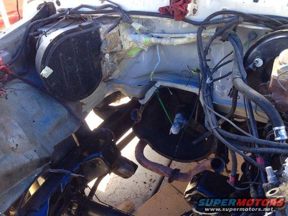 Engine bay with exposed components, wiring, and exhaust pipe