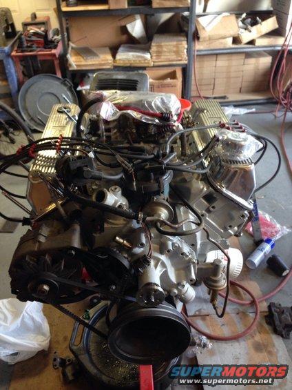 Engine assembly with chrome valve covers and black belts on a stand