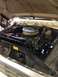 1978 Ford Bronco - The engine compartment of a vehicle is shown with the hood open, revealing the engine and its components.