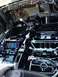 2004 Ford Crown Victoria - The interior floor pan of a car is coated in black, with exposed wiring and mechanical components visible.