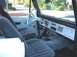 1967 Ford Bronco - The interior of this 1967 Ford Bronco features a white steering wheel and dashboard with a vintage radio.