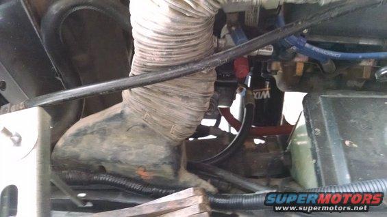 Engine bay with large corrugated hose, WIX oil filter, and blue "RACING" hose