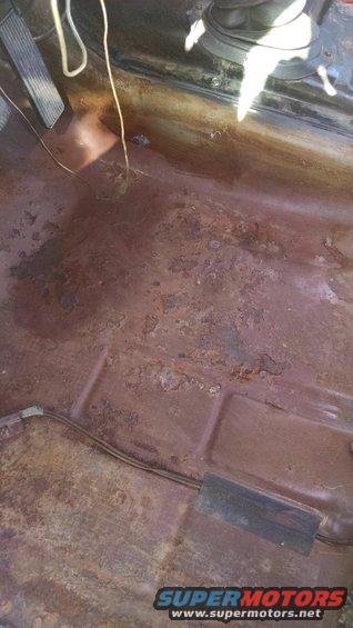 rusted floor pan with pedals visible