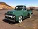 1954 Ford F-250 - A classic green Ford pickup truck is parked roadside with a scenic overlook in the background.