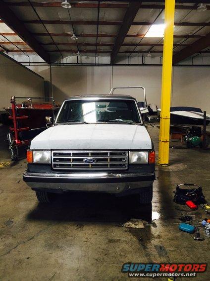 White Ford Bronco with a chrome grille and bumper, parked indoors