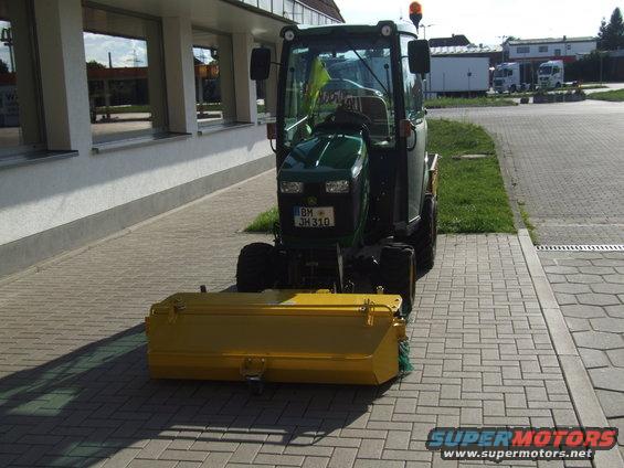 Green tractor with yellow front attachment and license plate BM JH310