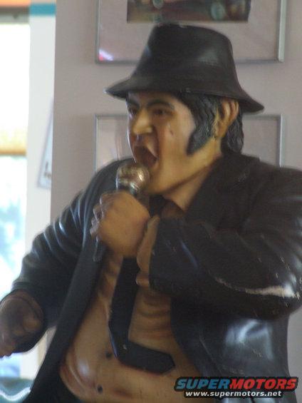 Statue of a man in a fedora and suit singing into a microphone