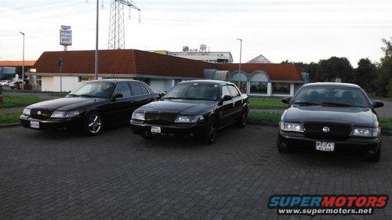 Three black 2003 Mercury Marauders parked in a lot, front view
