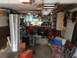 2004 Aston Martin Virage - A cluttered garage scene with tools, storage, and miscellaneous items.