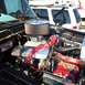 1979 Ford Bronco - The engine bay of a vehicle shows a V8 engine with custom modifications and a red battery.