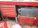 2004 Aston Martin Virage - A collection of tool chests are organized under a red workbench.