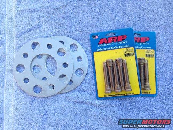 Two wheel spacers and two packages of ARP lug bolts on a towel