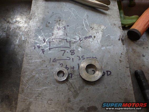 Two washers on a metal surface with handwritten measurements and diagrams