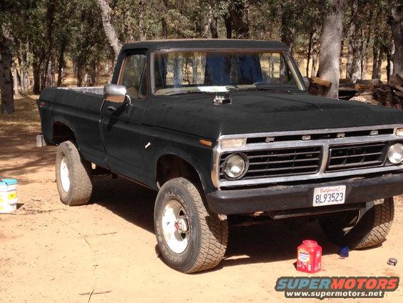 Black Ford pickup truck parked outside with trees in the background. License plate reads BL93523