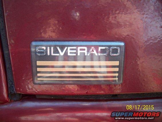 Red vehicle's Silverado badge with horizontal stripes