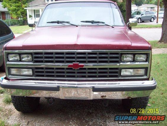 Front view of a red Chevrolet pickup truck with a chrome grille and bumper. Date stamp 08/28/2015