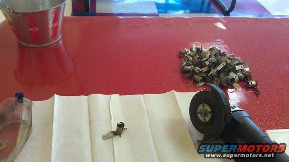 Angle grinder next to a pile of small metal clips and a single clip on paper towels