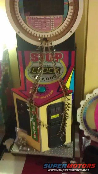 Arcade game with "Stop the Clock" text and a jackpot display, decorated with dried garland