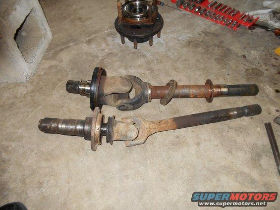 two driveshafts and a hub assembly on a concrete floor