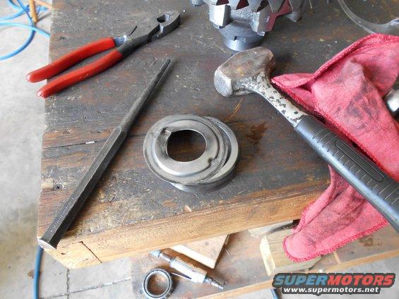 Metal bearing race and tools on a workbench