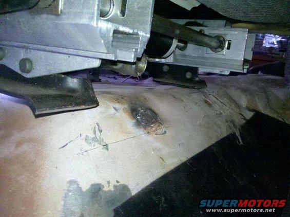 Close-up of vehicle underbody with metal brackets and floor pan
