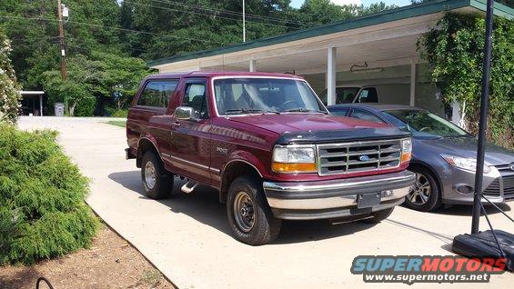 Maroon 1993 Ford Bronco parked next to a gray sedan