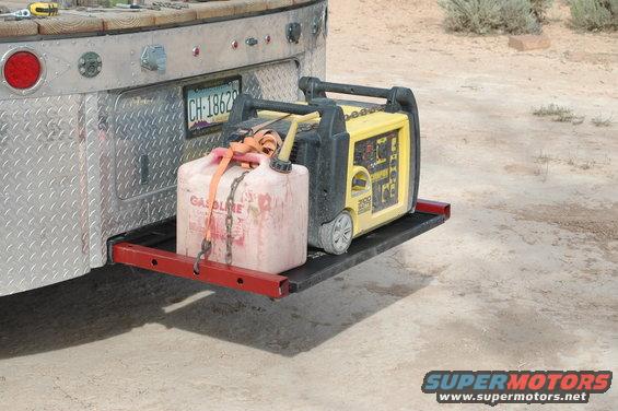 Yellow generator and red gas can secured to a metal rack on the back of a truck