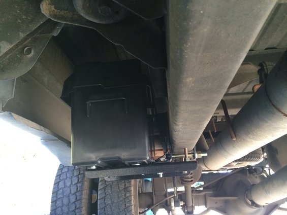 Underbody view of a 1997 Dodge 3500 showing a black auxiliary fuel tank mounted near the rear axle