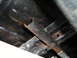 1978 Ford Bronco - Close-up view of the underbody frame and suspension components, showing signs of rust and wear.