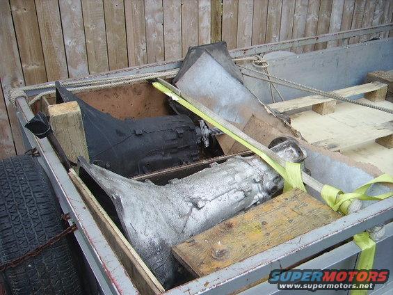 Two transmission assemblies secured in a trailer with wooden blocks and yellow straps