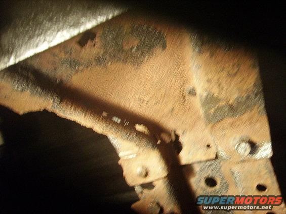 Close-up of heavily rusted metal frame components with bolts