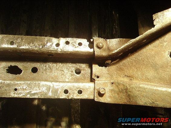 Close-up of rusted metal frame parts with holes, bolted together