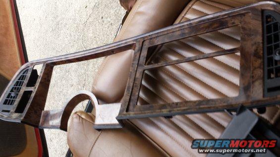 Woodgrain dashboard trim piece with air vents and openings for gauges